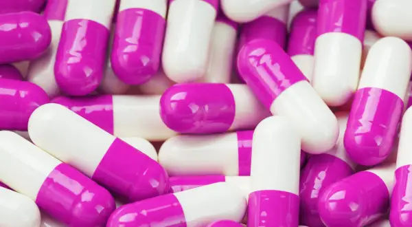 Mnóstwo białych i fioletowych kapsułek. Kiedy brac probiotyk? Zawsze warto skonsultować się z lekarzem lub farmaceutą.