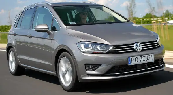 Szary Volkswagen Golf Sportsvan w ruchu drogowym. Wady tego modelu mogą obejmować ograniczoną przestrzeń bagażową w porównaniu do innych kombi.