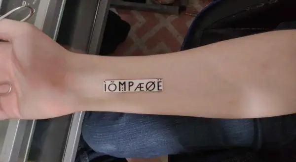 Nowy tatuaż na przedramieniu: ÌÕMPÆØË. Wygląda jak tajemniczy symbol.