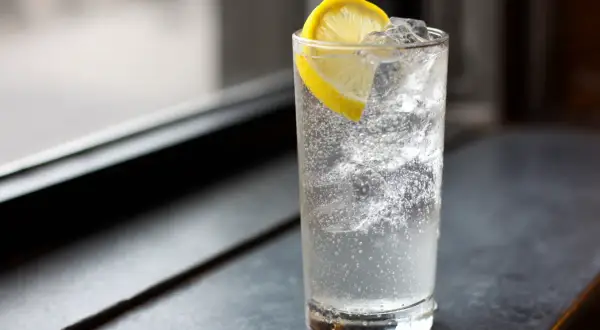 Ett glas med bubbligt vatten, is och en citronskiva. En perfekt enkel drink för en varm dag.
