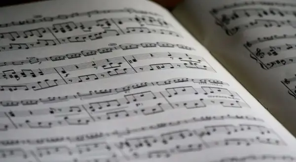 Otwarta księga z nutami, idealna do nauki, jak czytać nuty. Linie i symbole tworzą melodię.