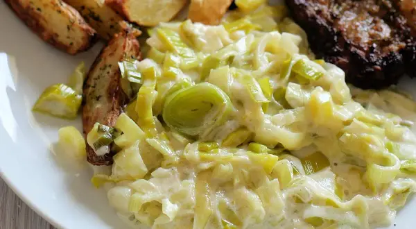 Cremiger Lauch, eine köstliche Beilage zu Steak und Kartoffelspalten. Perfekt für Lauch Rezepte.