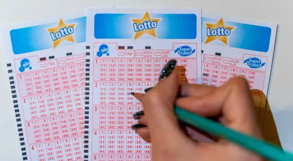 Ręka z ołówkiem zaznacza liczby na kuponach Lotto. Poznaj, jakimi metodami można zawierać zakłady gier liczbowych, wybierając swoje szczęśliwe cyfry.
