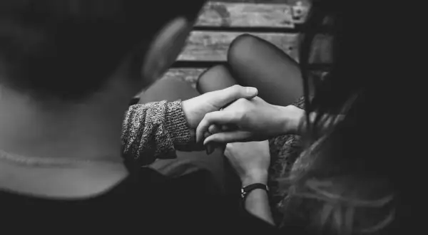 Manos entrelazadas, ¿es amor o dependencia emocional? La conexión se siente intensa en esta imagen en blanco y negro.