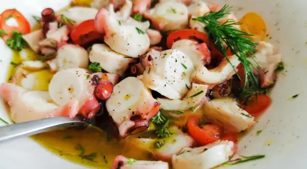 Ein köstlicher Pulpo Salat mit Tomaten und Dill in Olivenöl.