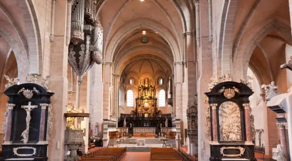 Innenansicht des Trierer Doms mit Orgel, Bänken und dem Hochaltar. Die dominformation trier ist beeindruckend.