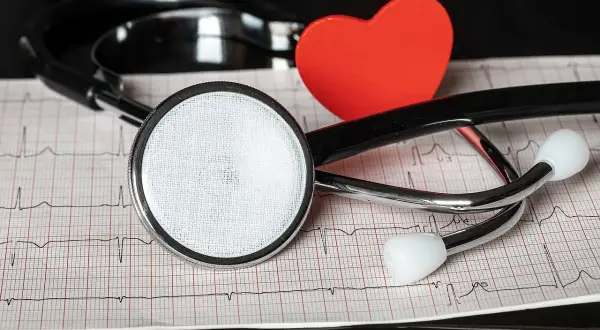 Stetoskop i czerwone serce na tle zapisu EKG. Dbamy o Twoje nt probnp.