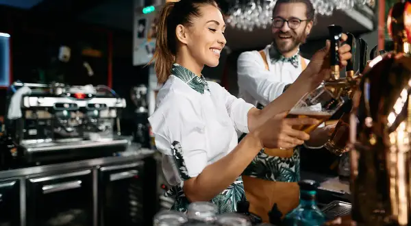 Uśmiechnięci barmani nalewają piwo. Zastanawiasz się, ile kosztuje koncesja na alkohol, by móc serwować takie napoje?