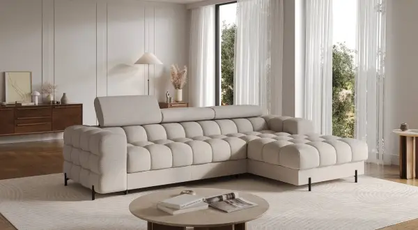 Ein helles Wohnzimmer mit einem beigen Ecksofa und einem runden oder eckigen couchtisch aus Stein und Holz.