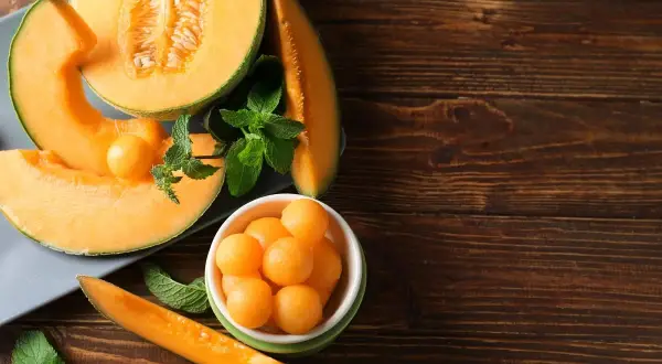 Soczysty melon, pokrojony w plastry i kulki, z listkami mięty. Idealna przekąska, niskie melon kcal.