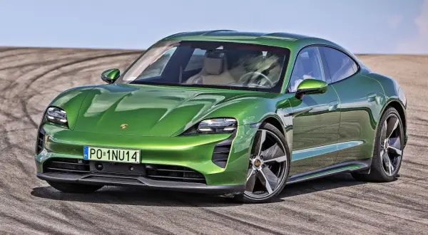 Zielony Porsche Taycan na torze, marka samochodu na P, z widocznymi śladami opon.