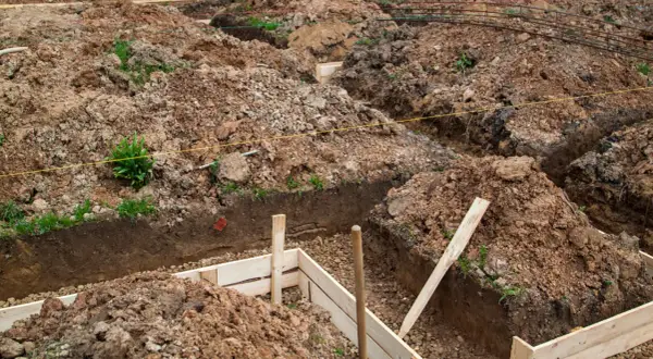Wykopy pod fundamenty, przygotowane do wylania betonu. Zastanawiasz się, ile kosztuje kopanie fundamentów? To kluczowy etap budowy.