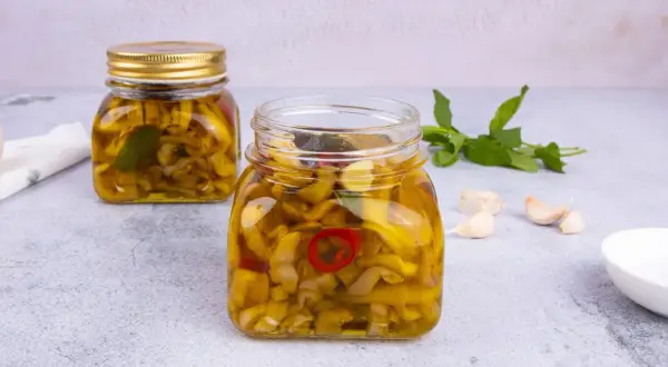 Melanzane sott'olio ricetta pugliese: vasetti pieni di sapore, con aglio e peperoncino.