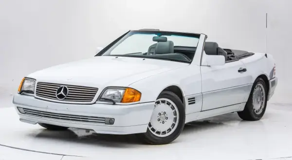 Biały kabriolet Mercedes-Benz SL500 z lat 90. z szarym wnętrzem, gotowy na letnią przejażdżkę.