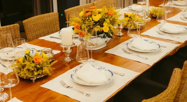 Elegancki stół z kwiatami i świecami, gotowy na przyjęcie. Piękne nakrycia i zastawa tworzą wyjątkowy **menu na wesele w domu**.