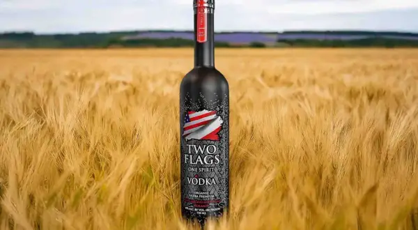 Butelka wódki Two Flags na tle złotego pola. Zastanawiasz się, ile kalorii ma setka wódki czystej?