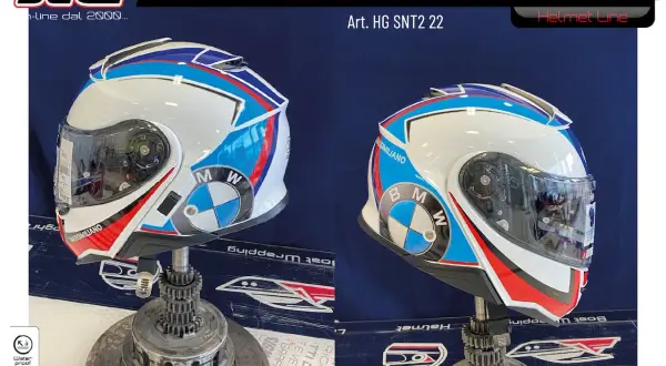 Casco integrale bianco con grafiche BMW blu, rosse e bianche. Si possono attaccare adesivi sul casco per personalizzarlo.