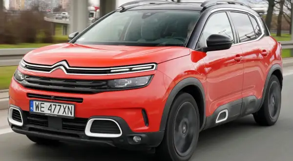 Czerwony Citroen C5 Aircross na drodze. Wiele pozytywnych citroen c5 aircross opinie potwierdza jego komfort i styl.