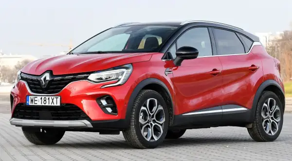 Czerwony Renault Captur na tle miejskiego krajobrazu. Zastanawiasz się, renault captur jaki silnik wybrać?