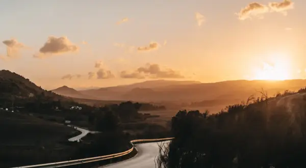 Kurvige Straße in Andalusien bei Sonnenuntergang. Berge und Täler in warmen Farben, ein Highlight der Landschaft.