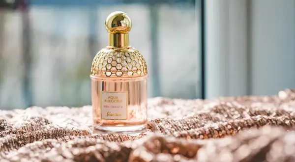 Elegancka butelka perfum Guerlain Aqua Allegoria Pera Granita na błyszczącym materiale. Czy Notino ma oryginalne perfumy? Tak, to dowód.