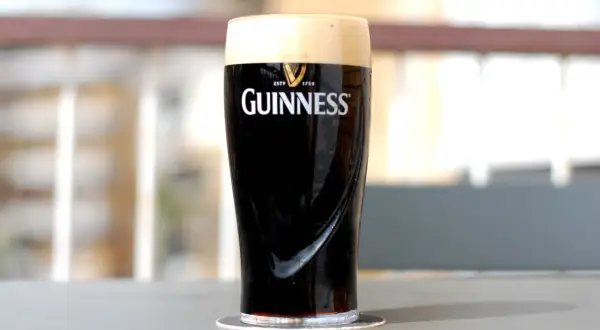 Un bicchiere di birra scura irlandese Guinness, con la sua iconica schiuma cremosa, pronto per essere gustato.