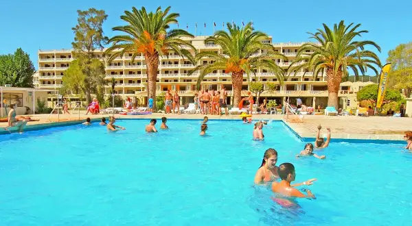 Słoneczny dzień na basenie w Messonghi Beach Holiday Resort. Rodziny kąpią się i bawią w wodzie.