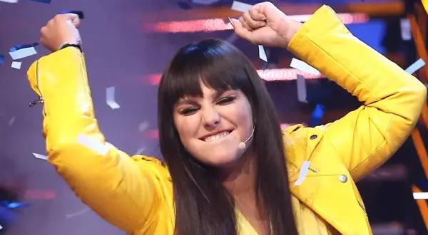 Ewa Farna w żółtej ramonesce, z uniesionymi rękami i konfetti, śpiewa "Bez łez".