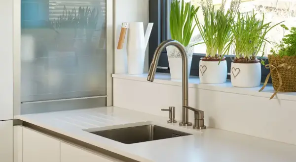 Nowoczesny parapet w kuchni inspiracje: biała konewka, doniczki z sercami i zielone rośliny tworzą przytulną atmosferę.
