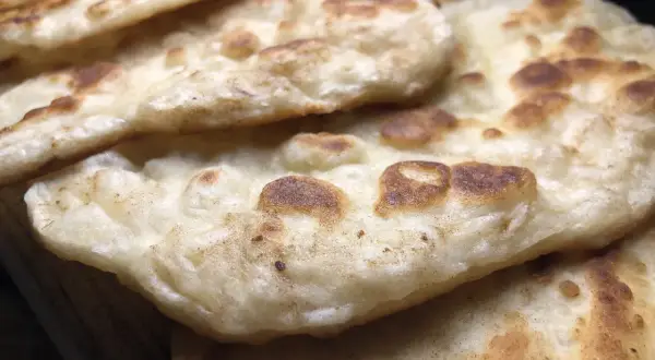 Stos chlebków naan, idealnych do indyjskich dań. Gdzie kupić świeży chlebek naan?