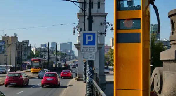 Żółty fotoradar na moście, obok znaku parkingu. Zastanawiasz się, po jakim czasie przychodzi mandat z fotoradaru?