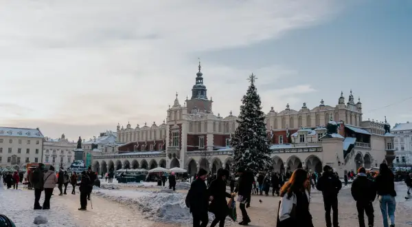 Zimowy Rynek Główny w Krakowie z choinką i ludźmi. Idealne miejsce na darmowe wydarzenia w Krakowie.