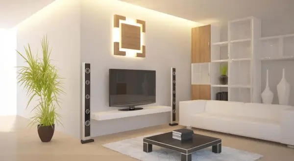 Modernes Wohnzimmer mit indirekter Beleuchtung an der Wand, die eine warme Atmosphäre schafft. Ein Fernseher, weiße Couch und ein Couchtisch sind zu sehen.