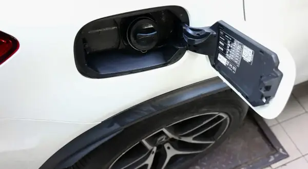 Otwarty wlew paliwa w białym Mitsubishi ASX 1.6 benzyna. Widoczny korek i tabliczka informacyjna.