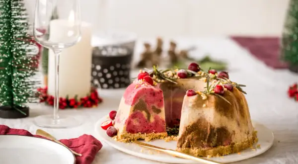 Festliches Eis-Weihnachten: Marmorierte Eistorten mit Cranberries und Rosmarin, dekoriert für ein festliches Mahl.