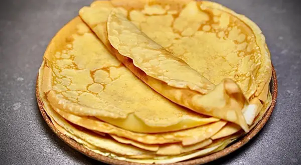 Pile de crêpes dorées et moelleuses, parfaites pour une recette facile.