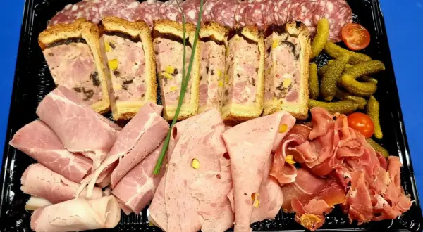 Plateau de charcuterie : terrines, jambon, saucisson, cornichons et tomates cerises. Idéal pour savoir que mettre dans un plateau de charcuterie.