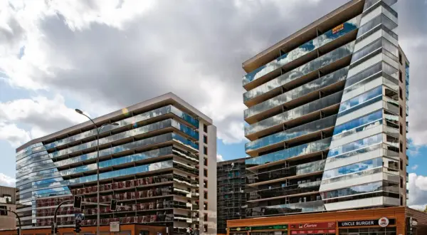 Nowoczesne apartamentowce z przeszklonymi fasadami odbijają chmury. Zastanawiasz się, dlaczego deweloperzy nie podają cen?