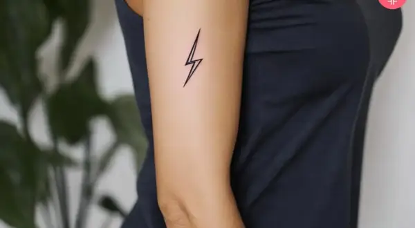 Delikatny tatuaż pioruny na ramieniu, symbolizujący siłę i energię.