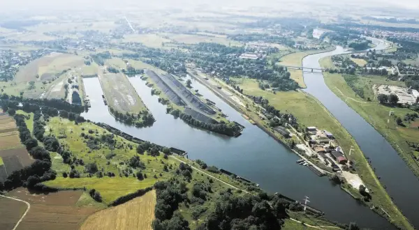 Widok z lotu ptaka na port rzeczny i kanały w Kędzierzynie-Koźlu. Widoczne barki, hałdy węgla i tereny przemysłowe. To jedne z kędzierzyn koźle atrakcje.