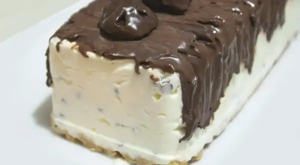 Pyszne lody cassate w kształcie bloku, oblane czekoladą i ozdobione czekoladowymi kuleczkami.