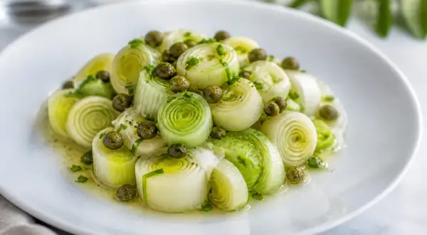 Poireaux vinaigrette, coupés en tronçons, nappés d'une sauce légère et parsemés de câpres. Un plat frais et savoureux.