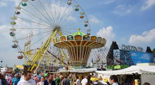 Buntes Treiben auf dem **Karpfhamer Fest** mit Riesenrad, Kettenkarussell und vielen Besuchern.