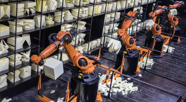 Roboterarme im Museum der Industriekultur formen weiße Objekte.