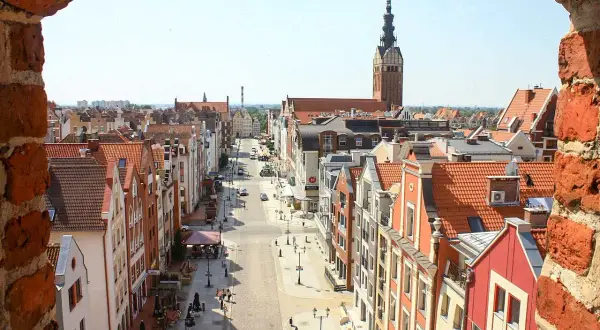 Widok na urokliwe kamieniczki i wieżę kościelną w Elblągu. Idealne miejsce, by odkryć, co zobaczyć w Elblągu i okolicy.