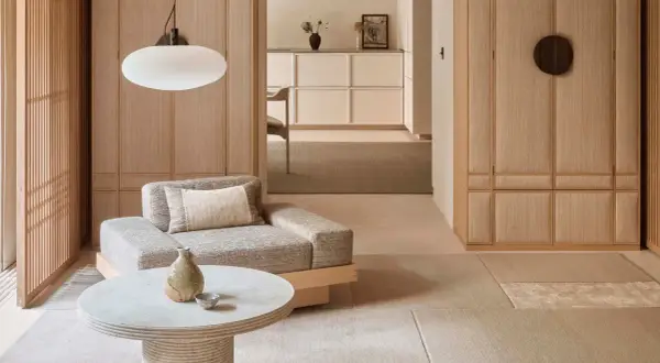 Gemütliches Wohnzimmer im Japandi Stil mit Sofa, Couchtisch und Holzelementen.