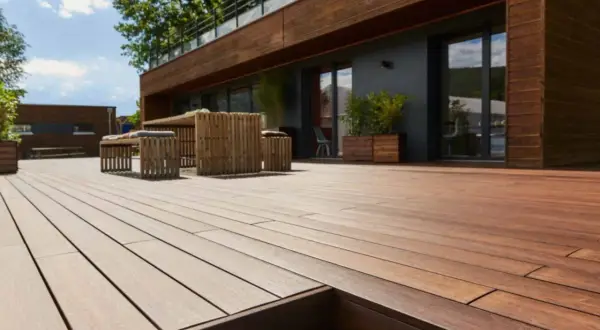 Terrazza in legno con mobili da esterno. La posa a secco, meglio sabbia o ghiaia, garantisce stabilità e drenaggio.