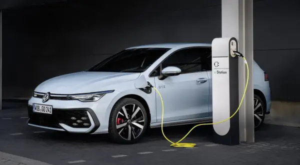 Jasnoniebieski Volkswagen Golf GTE podłączony do stacji ładowania e-Station.