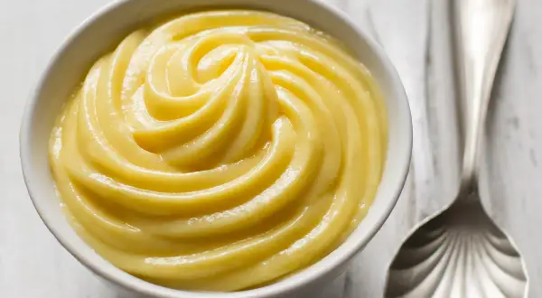 Una ciotola di cremosa crema pasticcera, liscia e invitante, pronta per essere gustata.