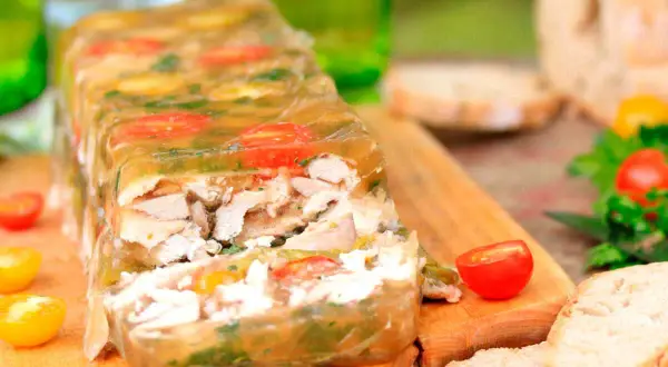 Un appétissant lapin en gelée, garni de tomates cerises et d'herbes, prêt à être dégusté avec du pain frais.